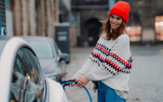 Mujer cargando vehículo eléctrico.