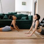 Dos chicas estudiates haciendo yoga en su piso alquilado