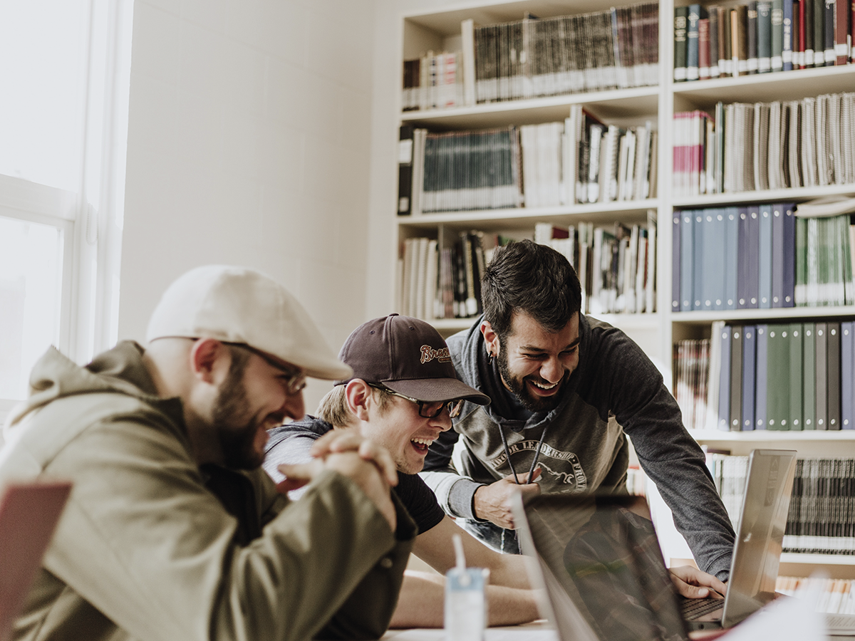 3 estudiantes contentos trabajando juntos