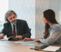 Una mujer y un hombre hablando en una oficina.