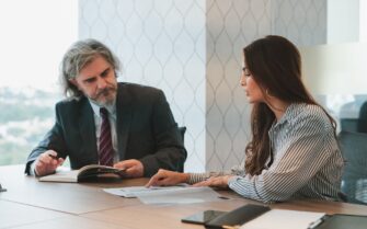 Una mujer y un hombre hablando en una oficina.