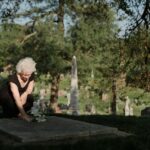 Mujer dejando flores a un ser querido en el cementerio_Cuánto cuesta morirse en España en 2024