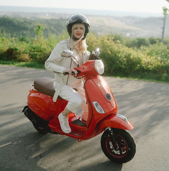 Chica encima de una moto roja
