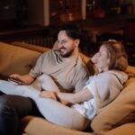 Pareja feliz en el sofá después de instalar domótica en su casa