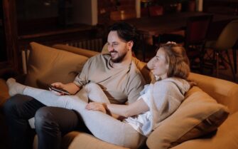 Pareja feliz en el sofá después de instalar domótica en su casa