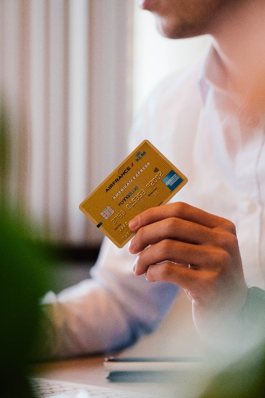 Un hombre aguantando una tarjeta de credito.