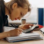 Mujer haciendo cálculos para ver su situación económica y ver cuanto ahorra