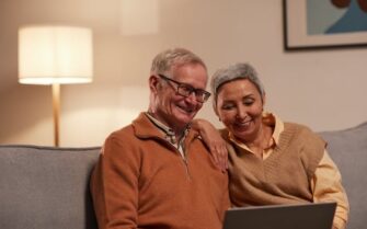 Dos personas mayores mirando sus pensiones en un ordenador.