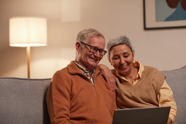 Dos personas mayores mirando sus pensiones en un ordenador.