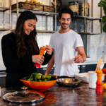 Una pareja preparando la comida en la cocina.