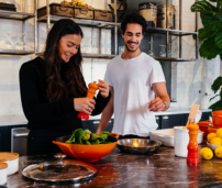 Una pareja preparando la comida en la cocina.