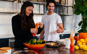 Una pareja preparando la comida en la cocina.