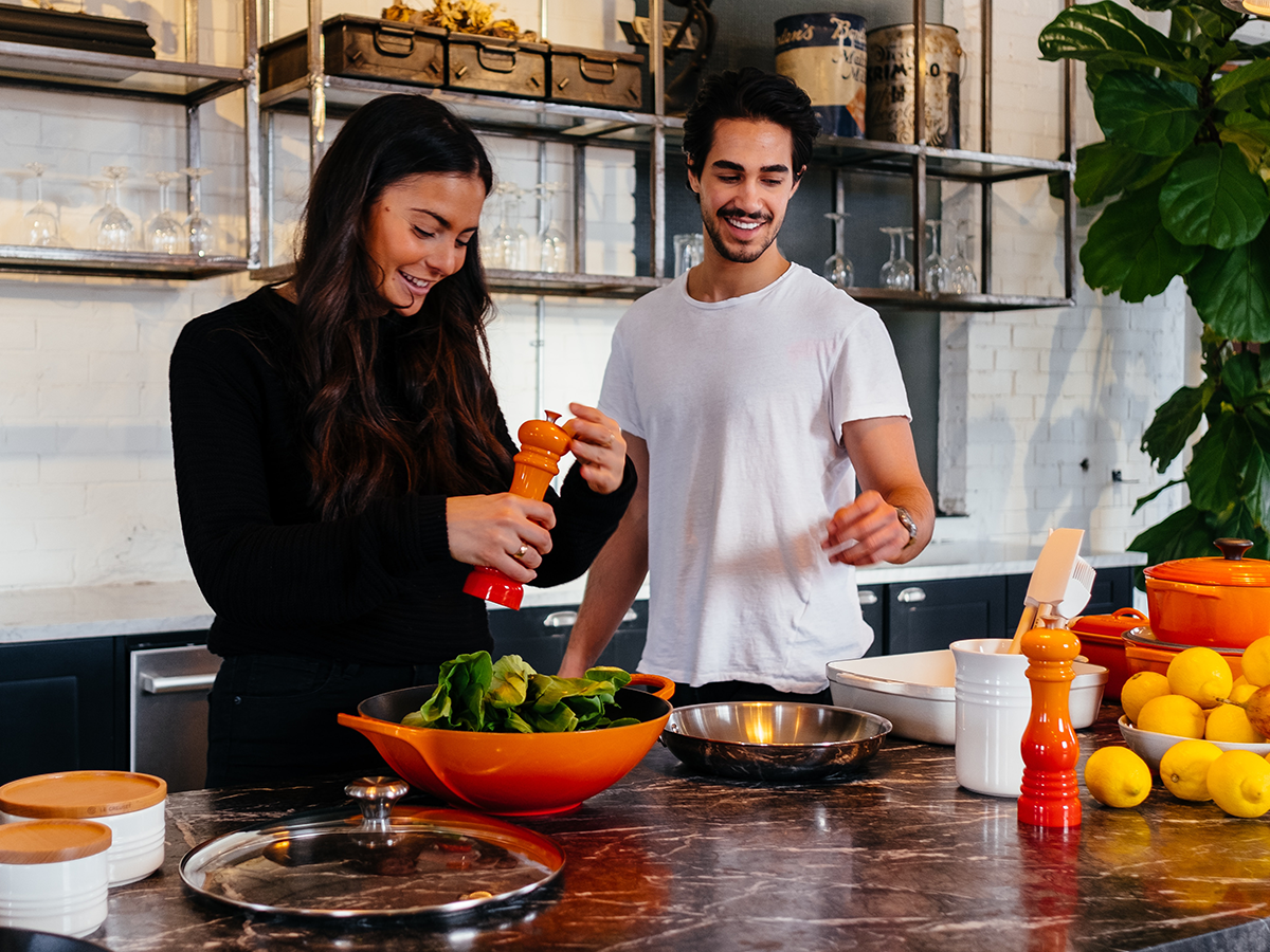 Una pareja preparando la comida en la cocina.