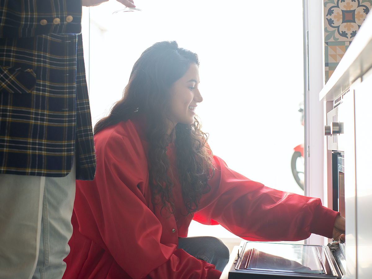 Mujer metiendo comida dentro del horno.