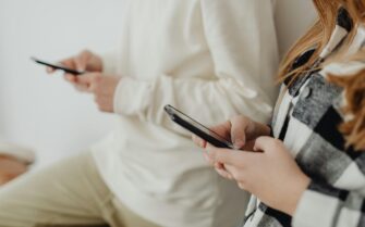 Dos personas, que están utilizando sus móviles.