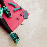Piernas en una esterilla con pesas y música