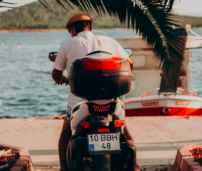 Hombre en una moto al lado del mar.