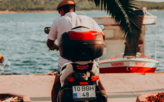 Hombre en una moto al lado del mar.