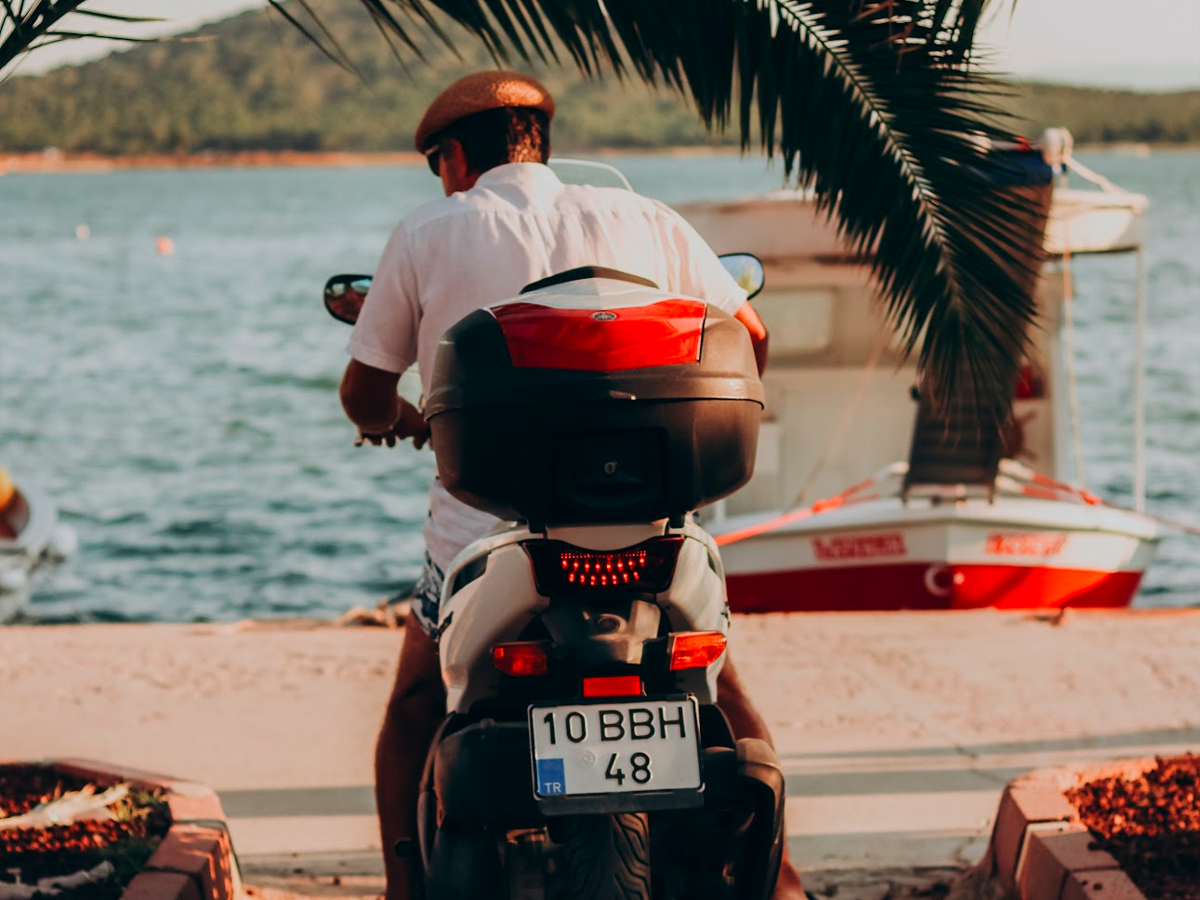 Hombre en una moto al lado del mar.