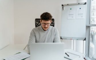 Persona observando su ordenador viendo qué hacer si le hackean la empresa