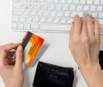 Mujer en su casa comprando online en su móvil con tarjeta de credito.