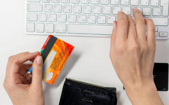 Mujer en su casa comprando online en su móvil con tarjeta de credito.