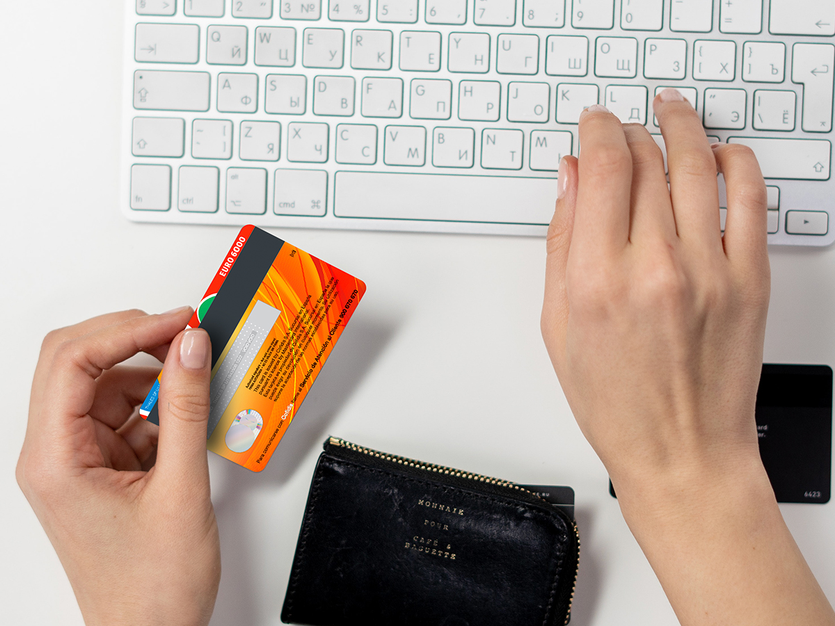 Mujer en su casa comprando online en su móvil con tarjeta de credito.