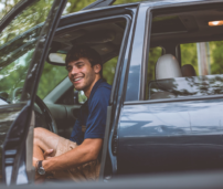 Hombre en el coche con la puerta abierta.