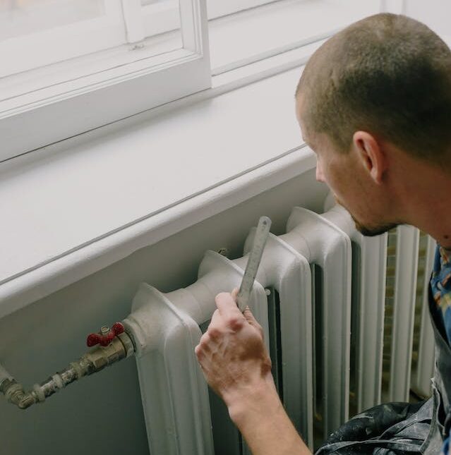 Hombre arreglando un radiador para ahorrar en calefacción