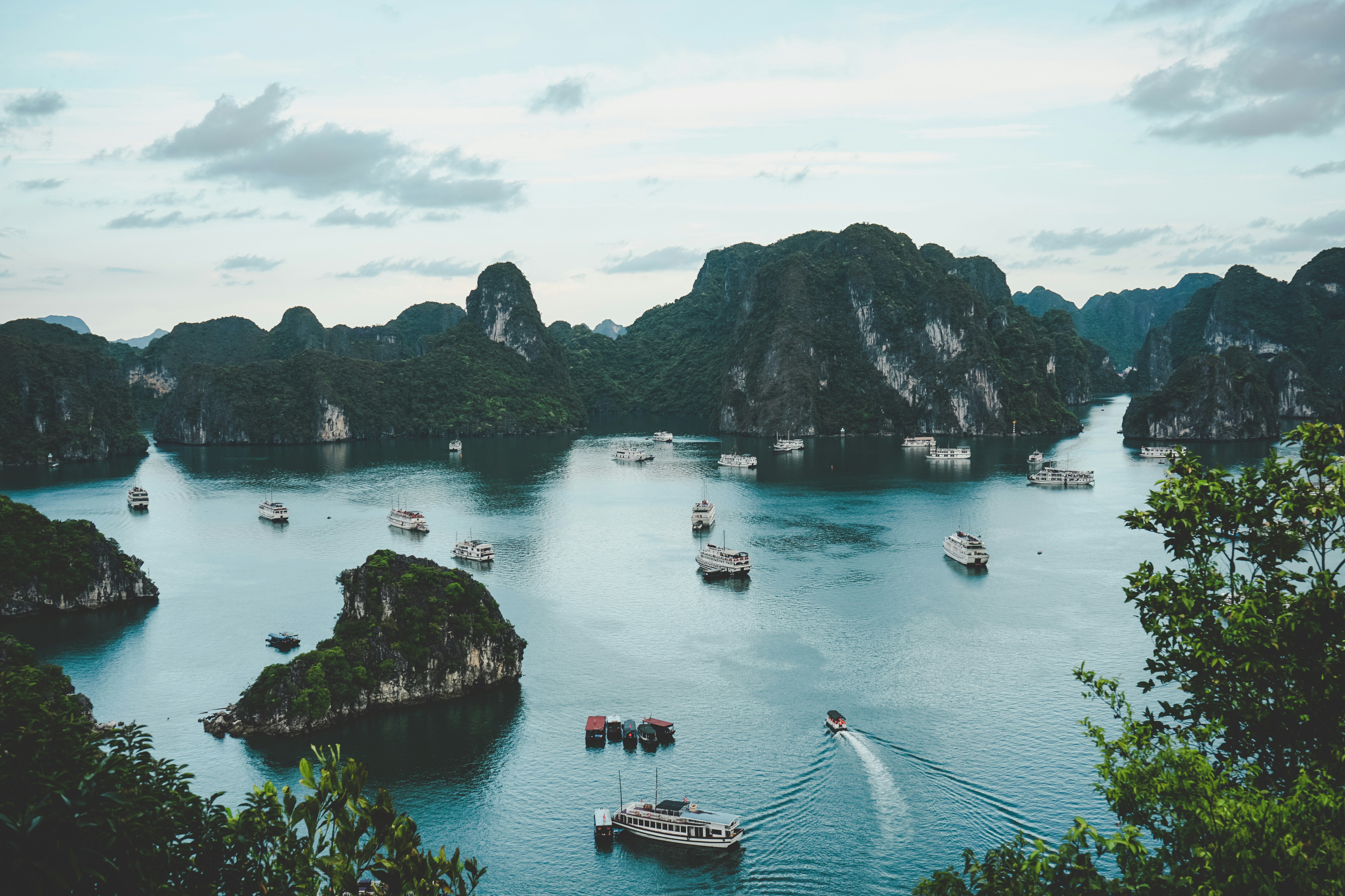 Atardecer en Halong Bay, uno de los destinos más turísticos de Vietnam Halong Bay lleno de barcos paseando entre las islas al atardecer