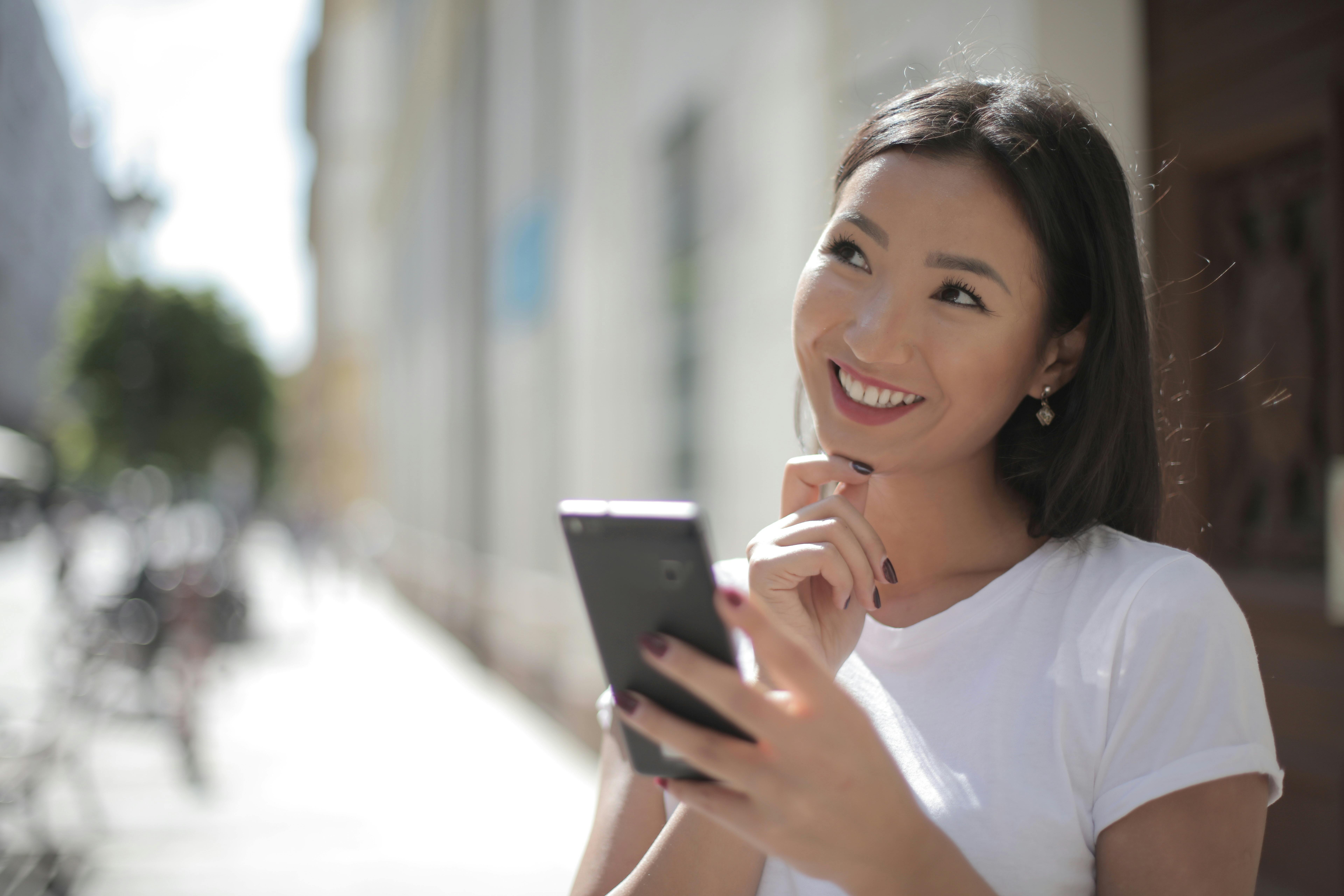 app_de_idiomas Una chica sonriendo y utilizando una app para aprender un idioma.