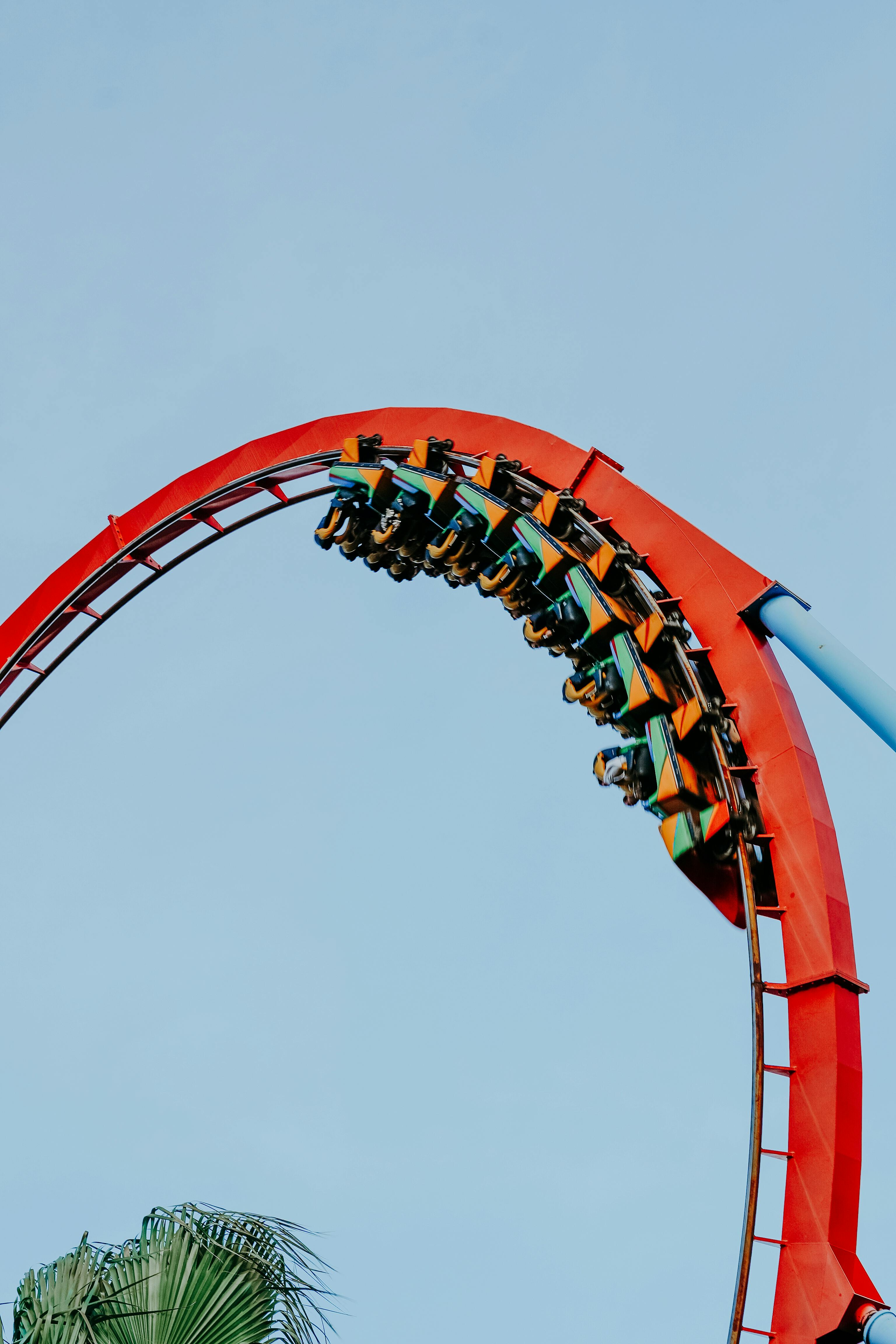 Montañas rusas de PortAventura World. Una montaña rusa de color rojo realizando un giro invertido en PortAventura World, destacando la oferta de aventura y diversión extrema del parque.