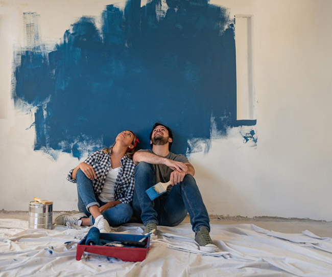 chica chico pintando pared azul