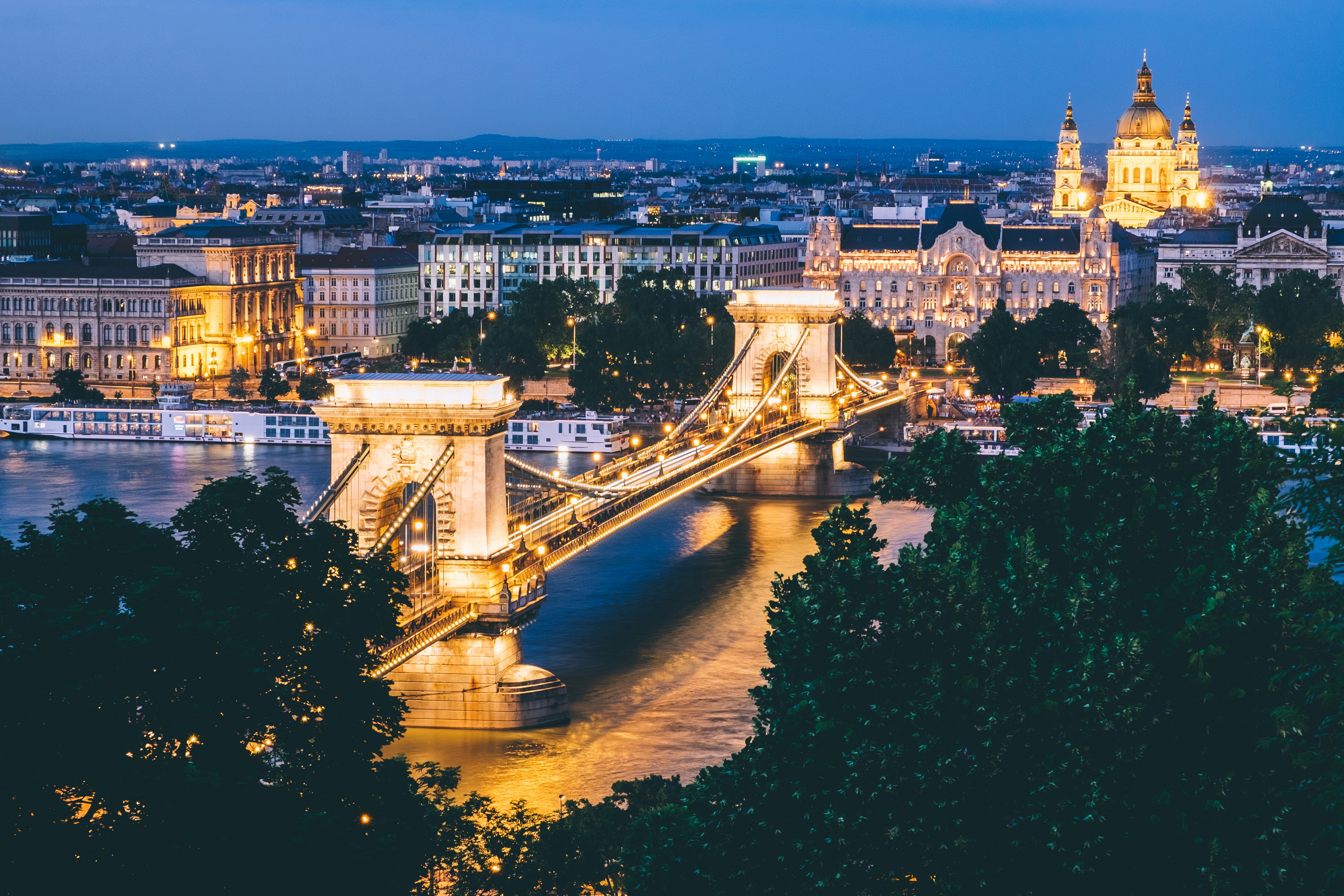 Uno de los puentes más famosos de Budapest El puente de las cadenas completamente iluminado con Budapest de fondo