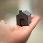 Mano sujetando una figura de una casa