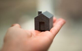 Mano sujetando una figura de una casa