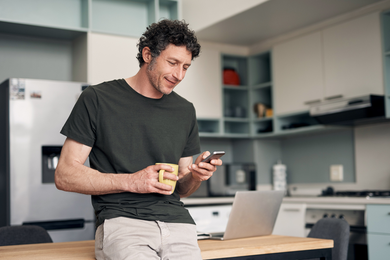 Hombre con móvil y taza