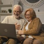 Dos personas mayores mirando sus pensiones en un ordenador.