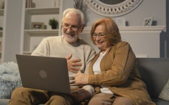 Dos personas mayores mirando sus pensiones en un ordenador.