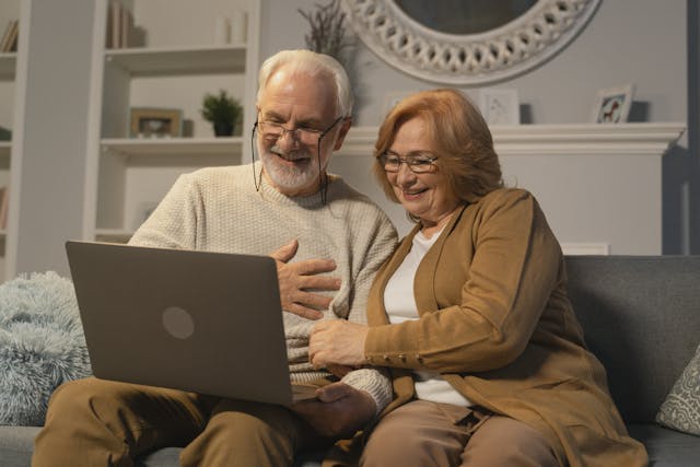 Dos personas mayores mirando sus pensiones en un ordenador.