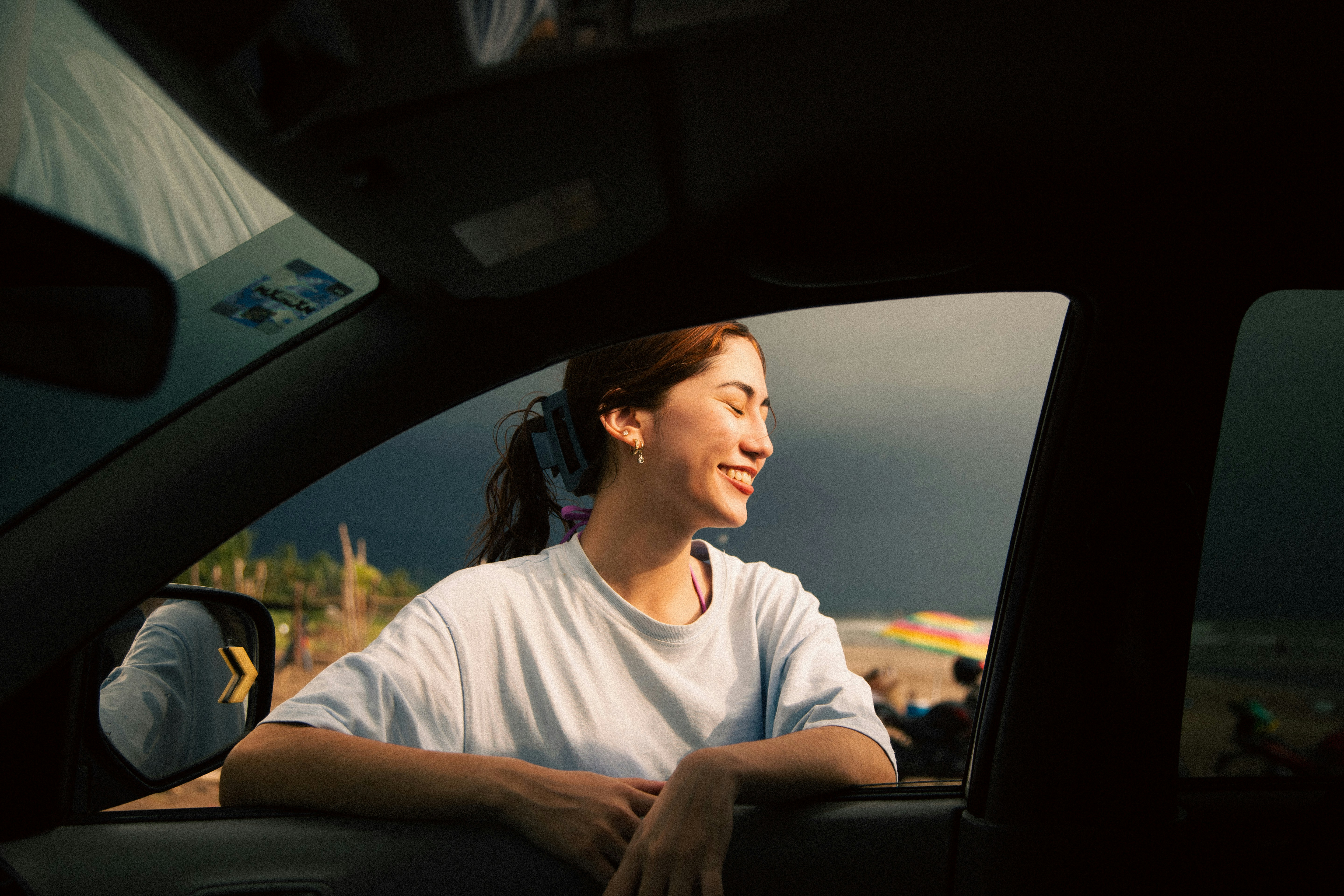 Mujer joven mirando por la ventanilla del coche Una joven mirando al horizonte desde un coche de segunda mano
