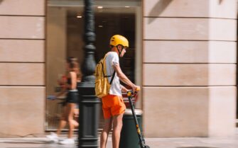 Chico desplazándose en patinete eléctrico por una ciudad