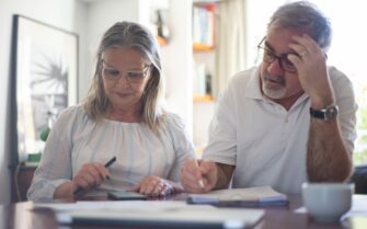 Hombre desempleado de más de 50 años revisa los gastos junto a su pareja