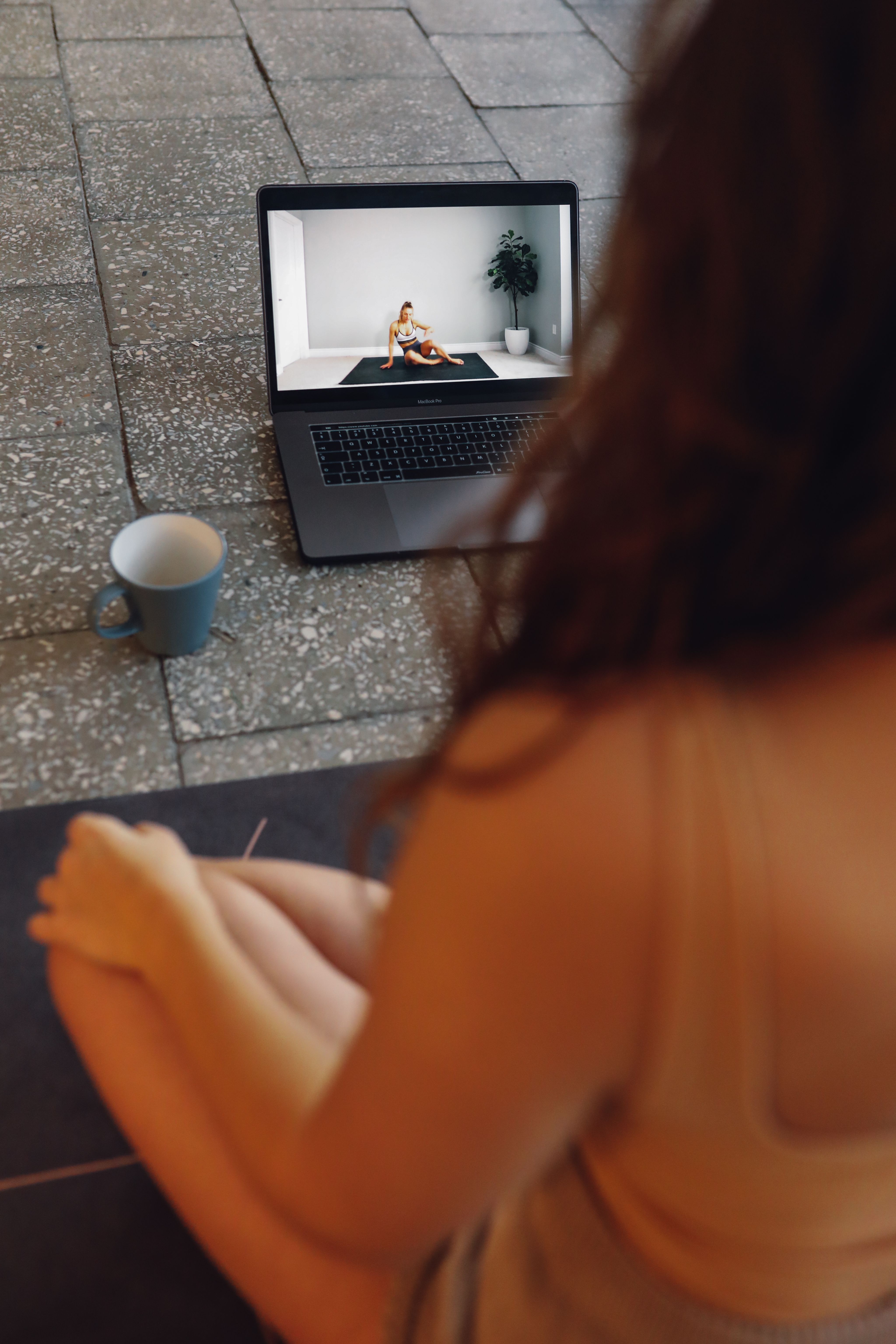 Internet está lleno de contenidos orientados a mejorar nuestro entrenamiento Mujer sentada viendo un videotutorial de entrenamiento mientras toma un café
