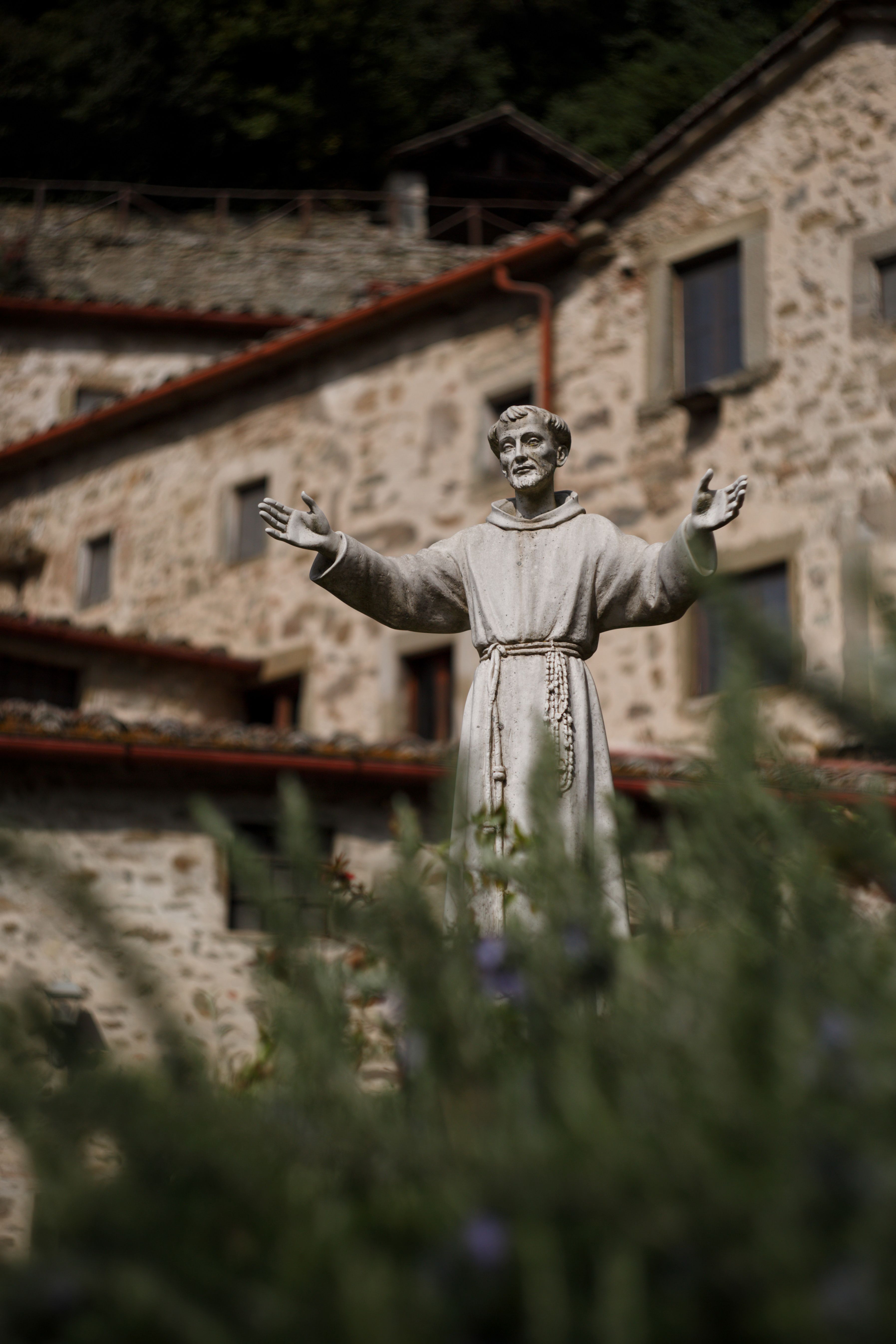Los brazos abiertos, un símbolo de la hospitalidad de los monasterios Una escultura de piedra de un monje con los brazos abiertos situada en un jardín