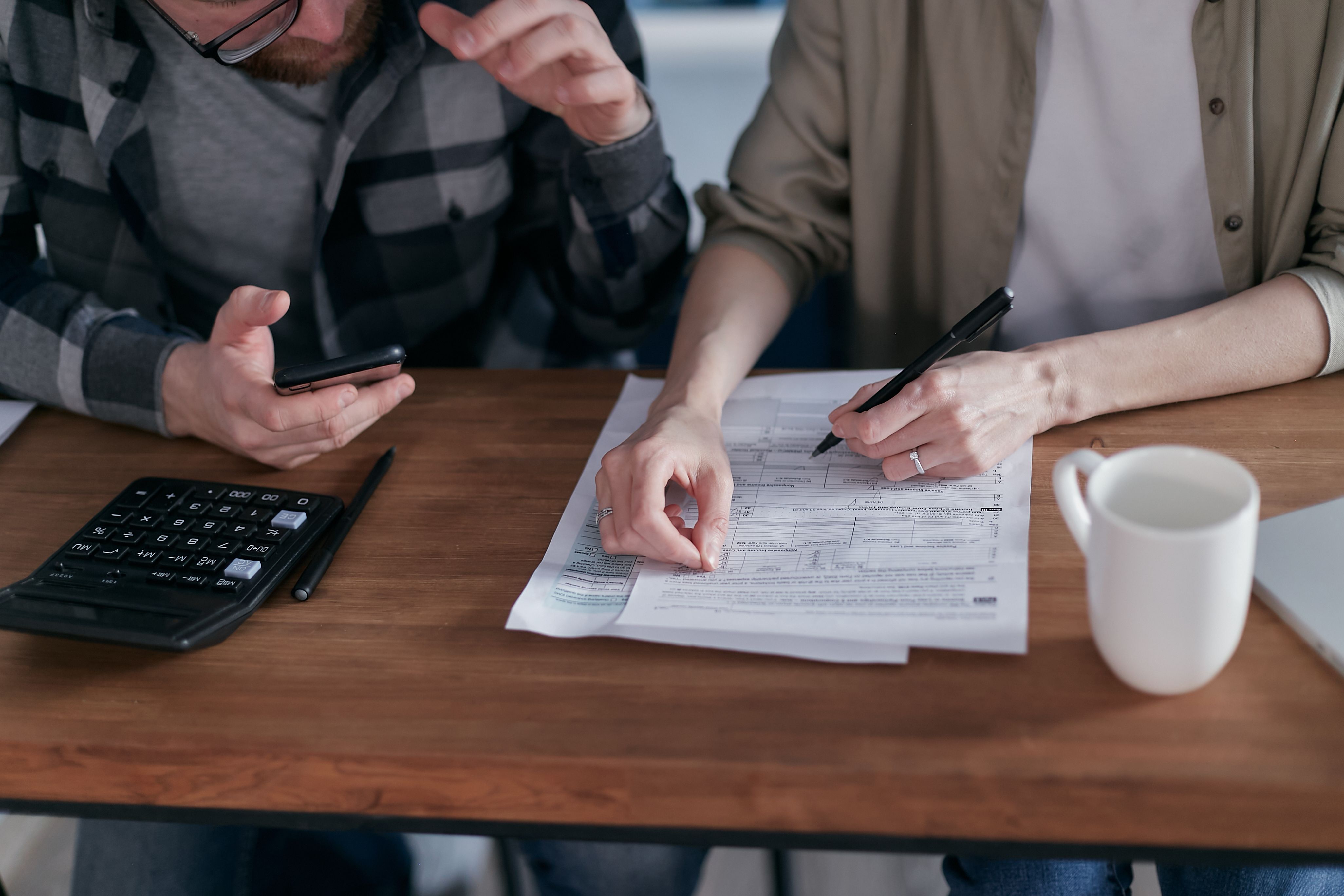 Una pareja revisando la documentación para solicitar un préstamo Familia hace números y revisa las condiciones de un préstamo bancario