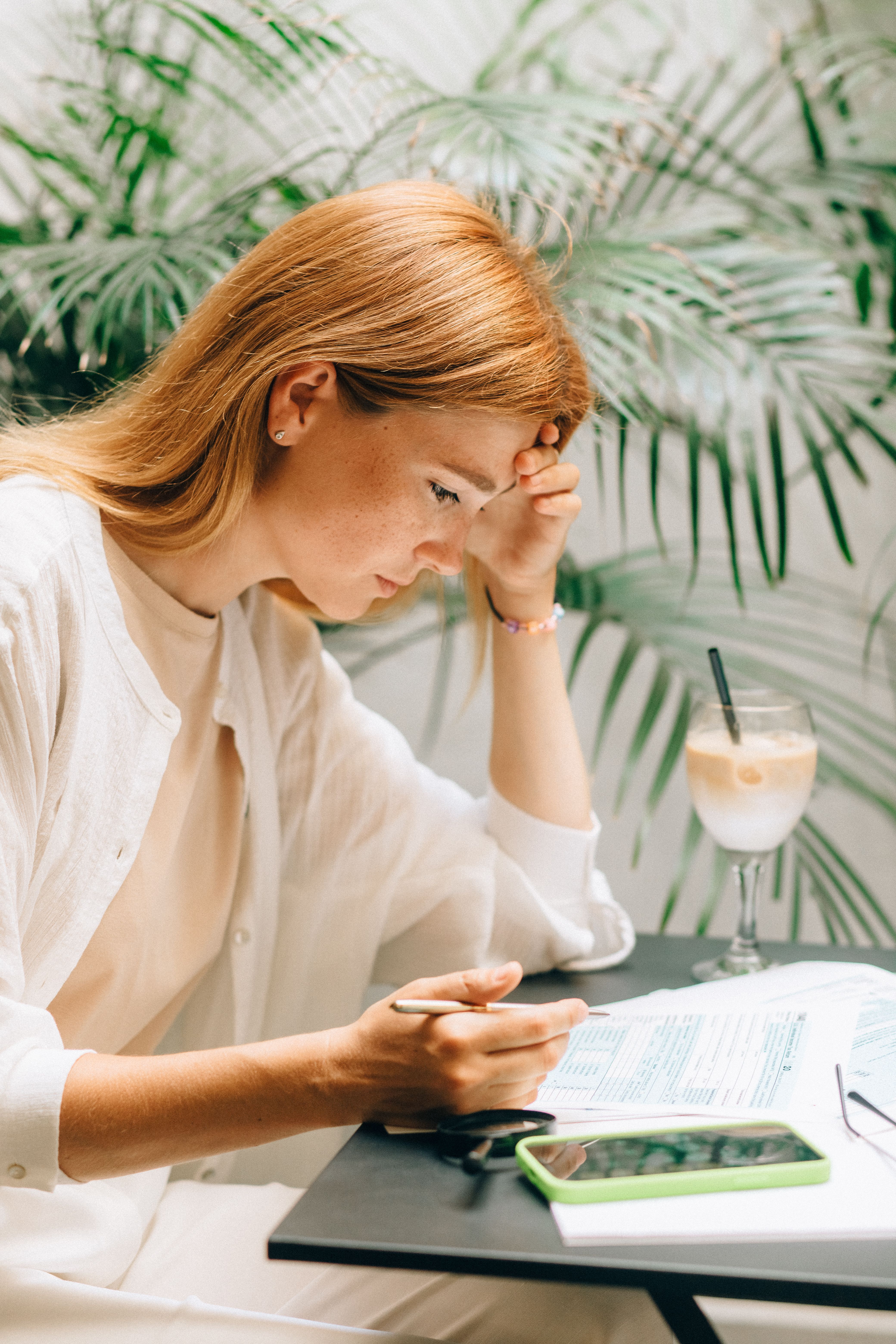 Hacer números es clave a la hora de cambiar de operador Mujer revisa la factura telefónica mientras toma algo