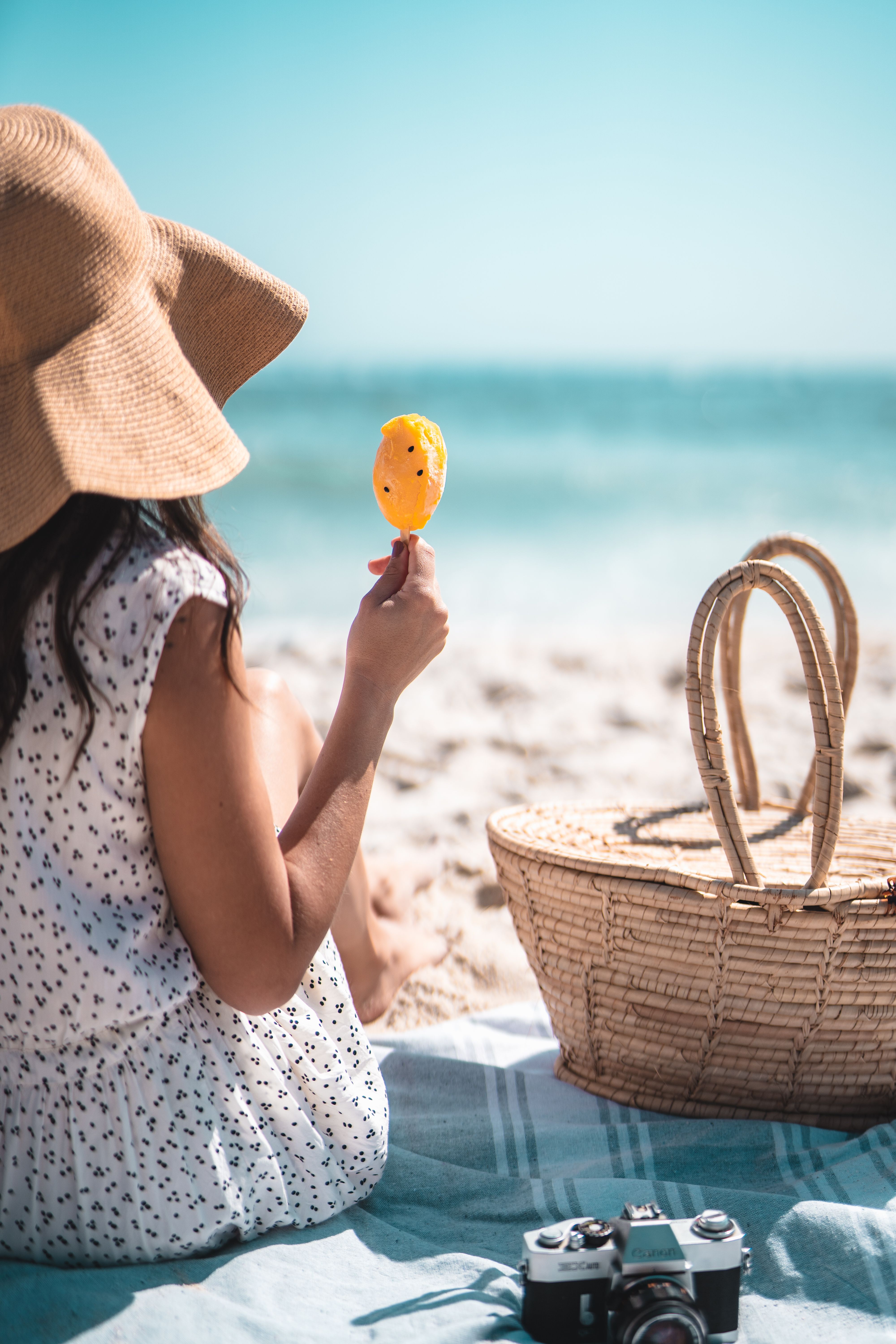 Llevar nuestra propia comida ayuda a ahorrar en vacaciones Niña disfrutando de un picnic de verano frente la playa