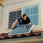 Un hombre, instalando una placa solar, el tejado de una casa
