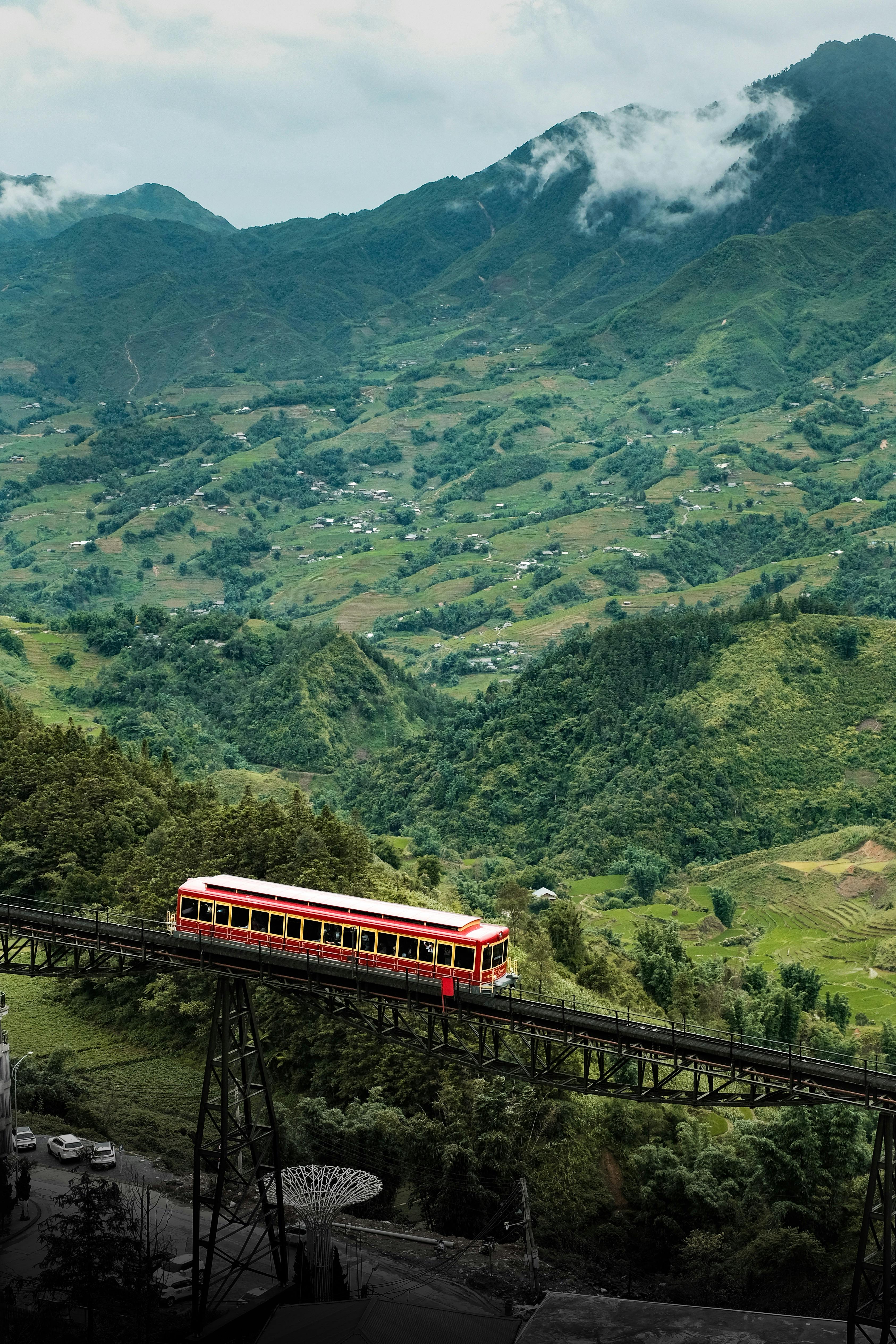 Desplazamientos en tren y ferrocarril por Vietnam Un tren recorriendo las montañas de Vietnam, representando las opciones de transporte ferroviario y trenes nocturnos para viajar entre ciudades.